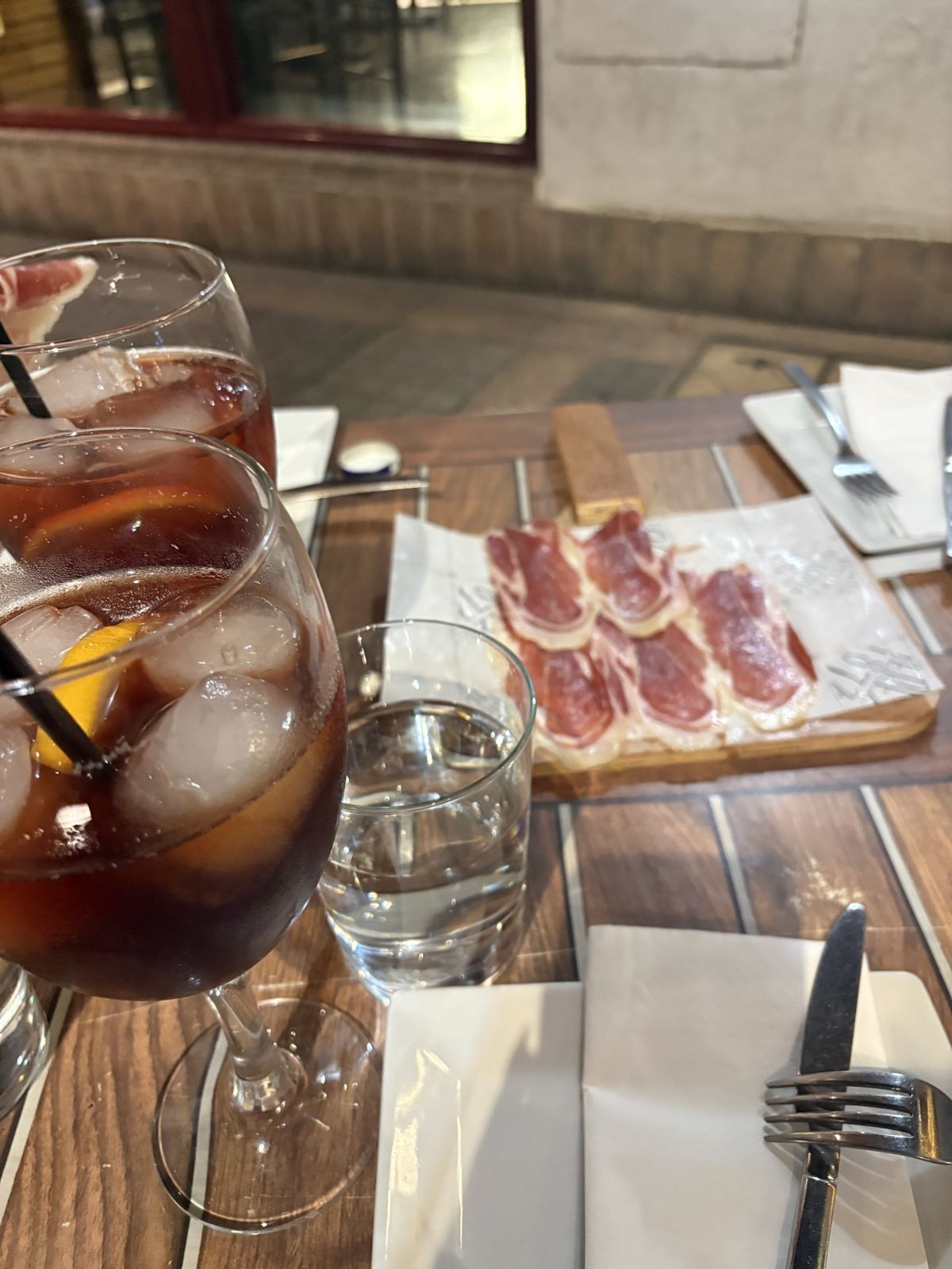 Deux verres de tinto de verano avec une tranche d'orange, et une planche de jambon ibérique